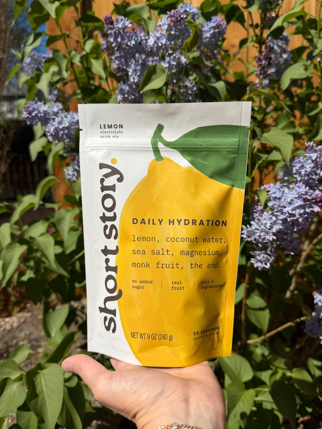 Short Story lemon electrolyte drink mix pouch held outdoors, 30 servings